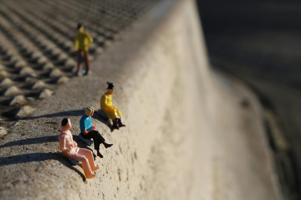 Tiny figurines arranged on concrete, highlighting perspective and texture.