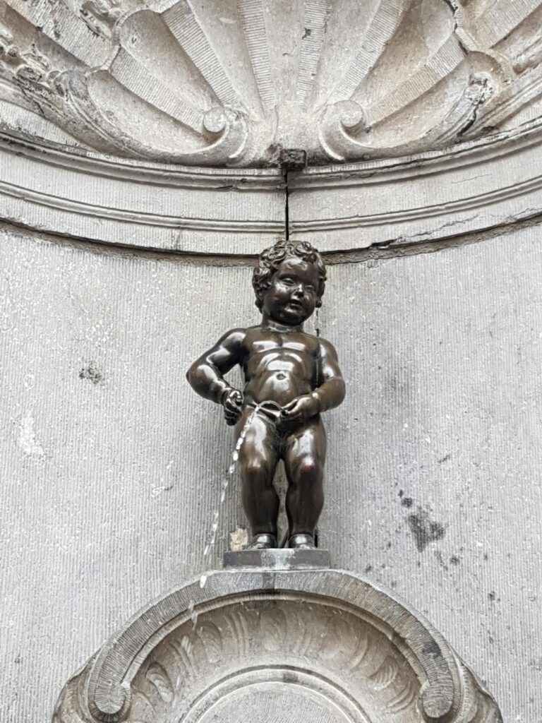 Famous bronze statue Manneken Pis in Brussels, Belgium, symbolizing local humor.
