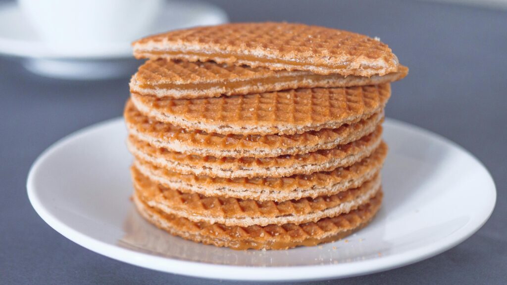 Mouth-watering stack of stroopwafels on a white plate, perfect for a tasty treat.