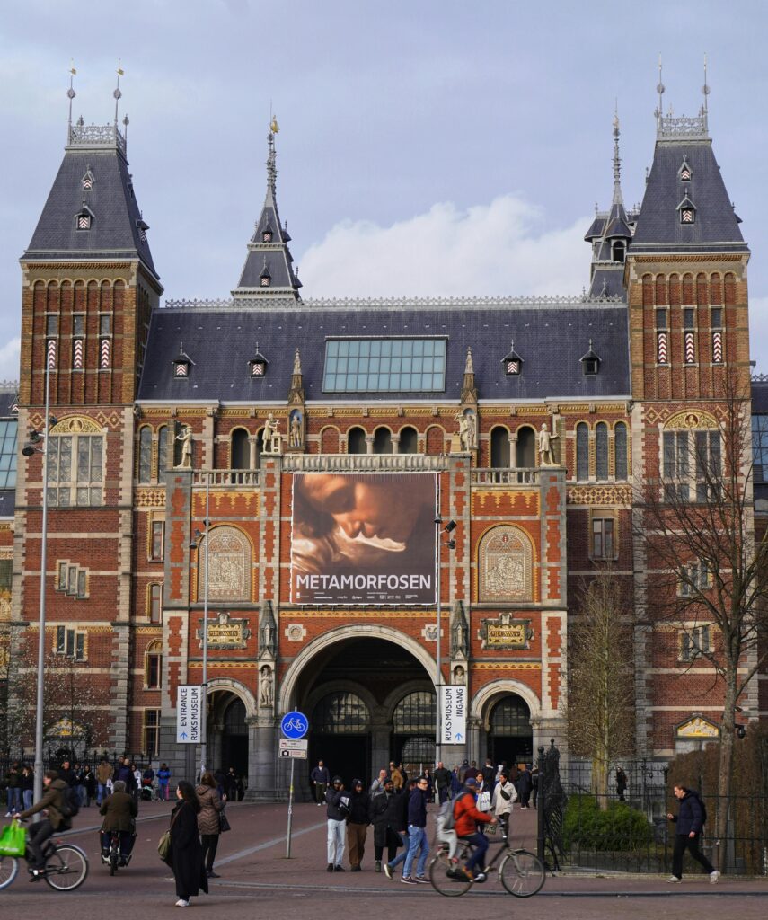 Front view of the Rijksmuseum in Amsterdam featuring the Metamorfosen exhibition banner.