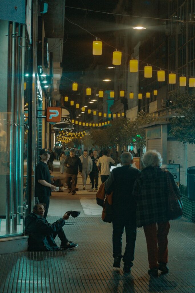 Night street view in Buenos Aires with crowds and yellow lanterns.